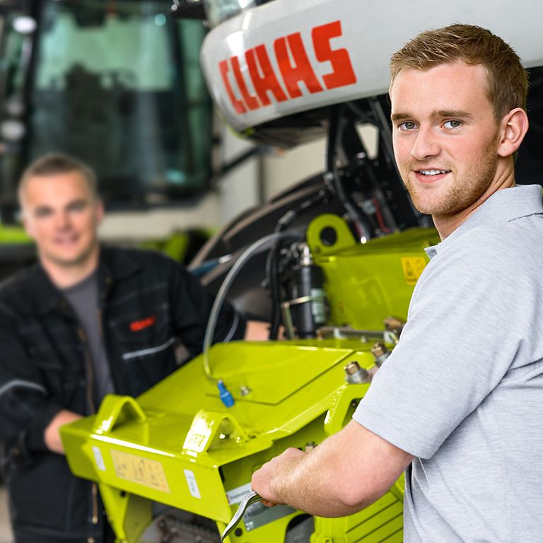 direct-entry-benefits-image Dos compañeros están delante de una picadora y sonríen a la cámara