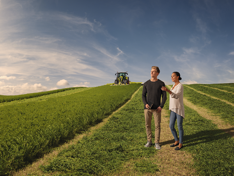 dual-studies Zwei Personen auf dem Feld vor einem Trecker.