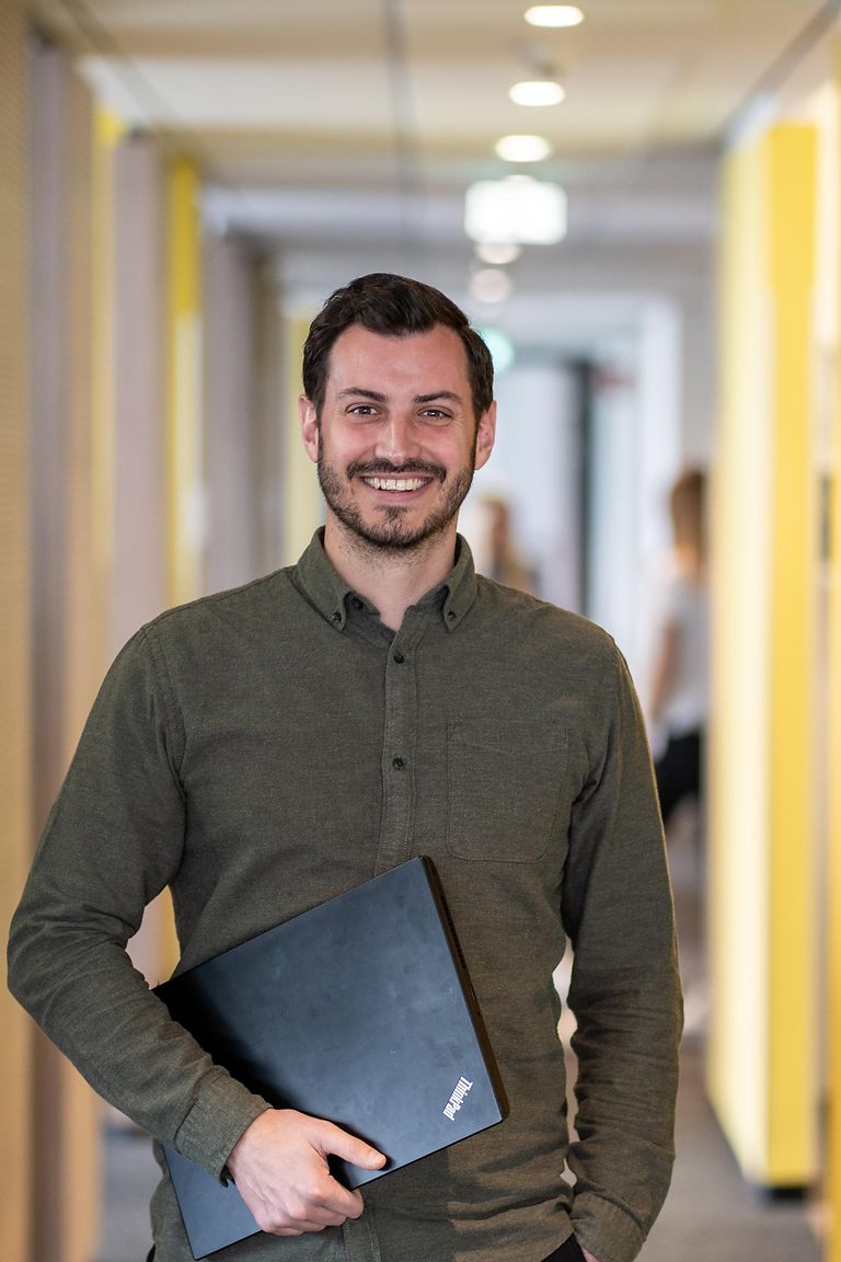 direct-entry-stage-pic Mann mit Laptop im Büroflur