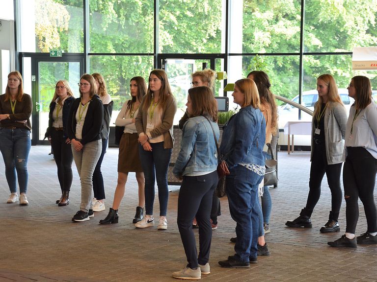 contact-pic-1-Besuchergruppen (1) Viele Frauen stehen in einem Halbkreis und hören einer Person zu.