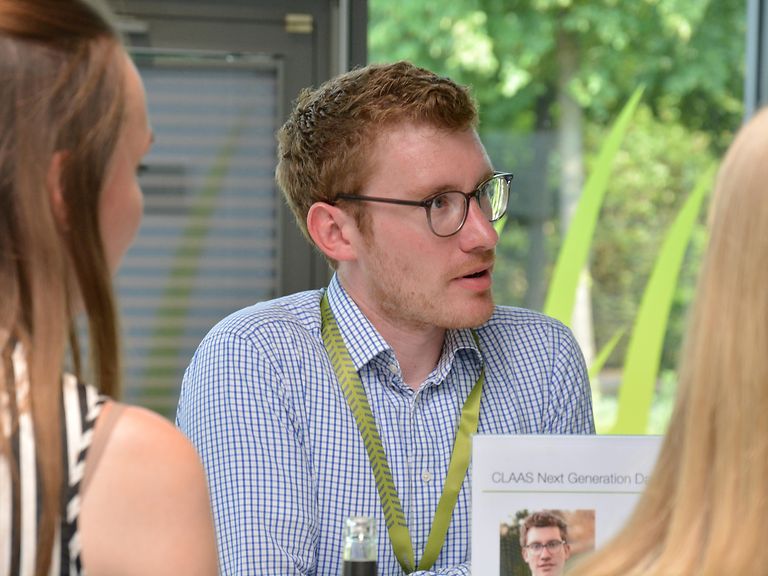 contact-pic-1-Messen Junger Mann im Gespräch mit zwei Frauen.