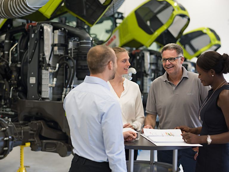working-areas-research-image Colleagues talking in front of tractors