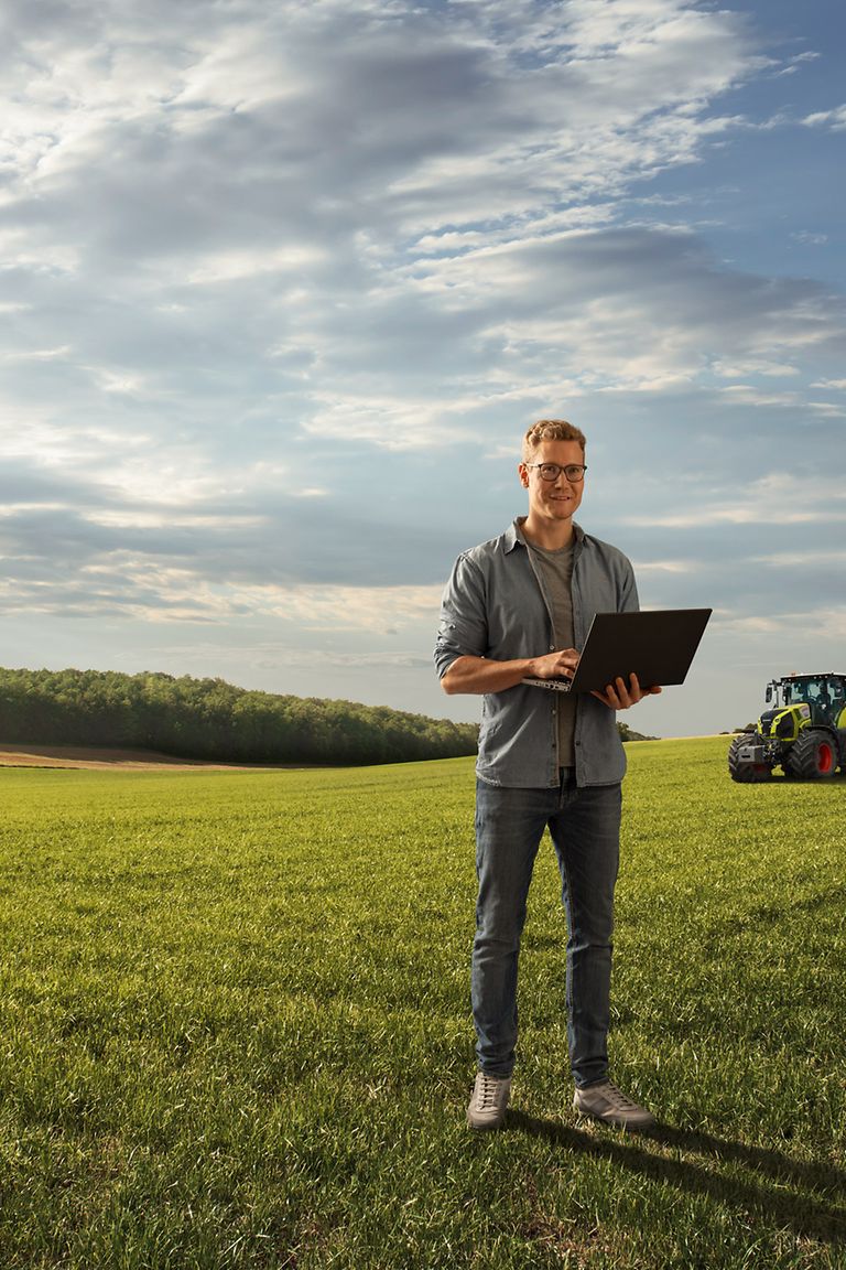students-stage-pic Hombre joven está con un ordenador portátil en una parcela