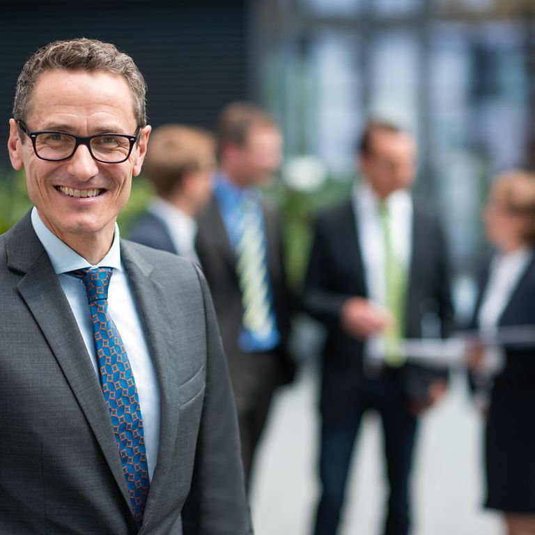 professionals-checklist Mann steht vor Gruppe Kolleg/-innen