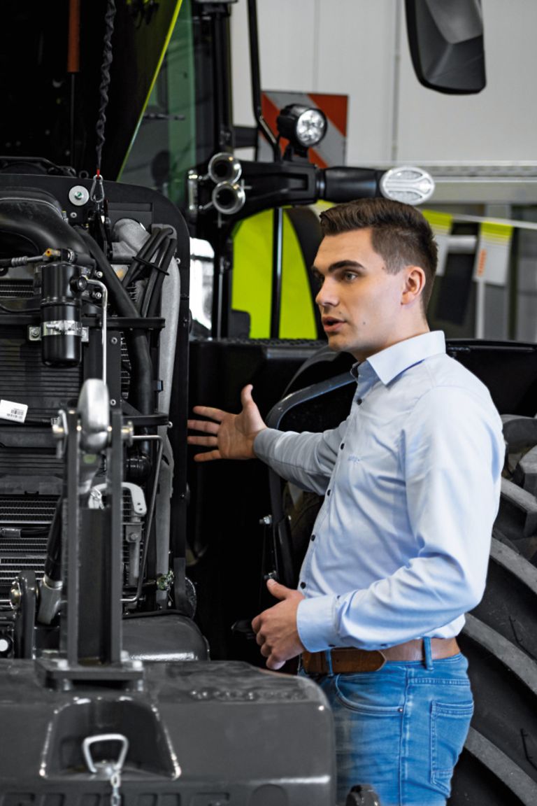 working-areas-stage-pic Kolleg;:innen stehen vor geöffneter Motorhaube von Traktor