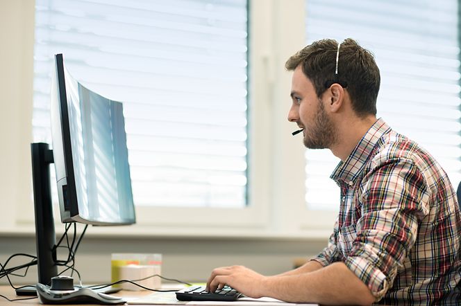 high-tech-meets-purpose-security-image Mann mit Headset vor Bildschirm
