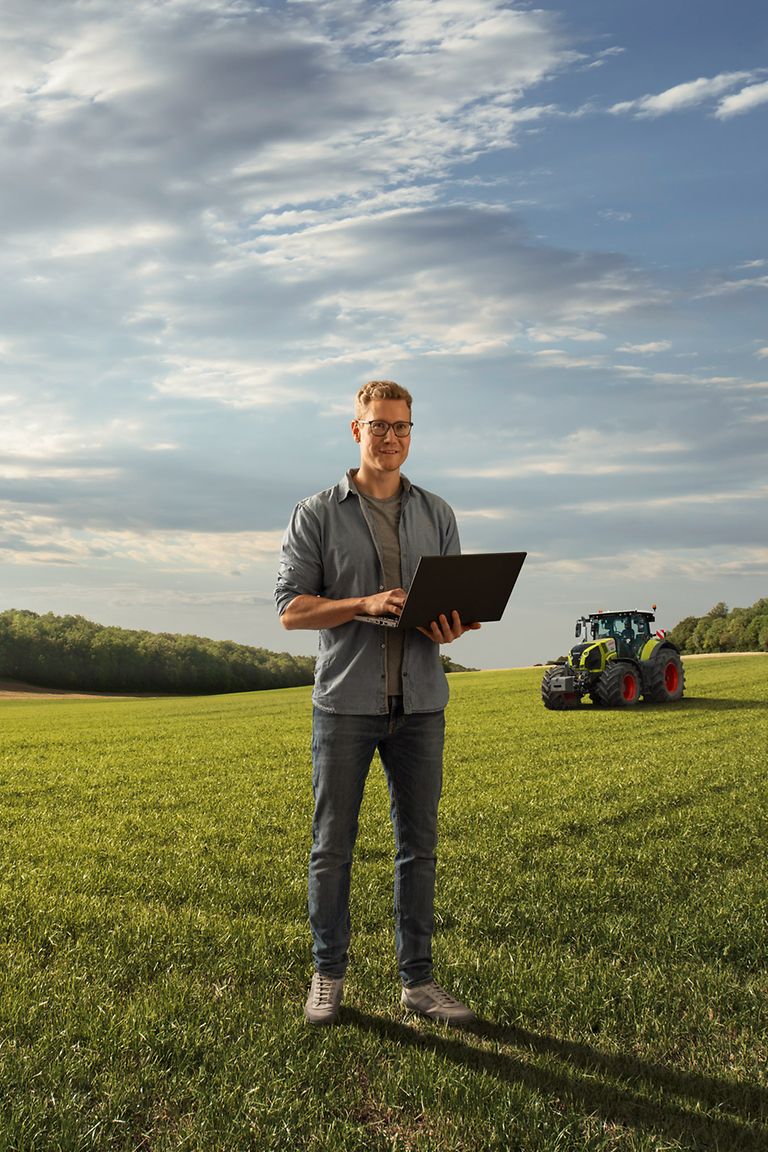 students-stage-pic Fiatal férfi áll a mezőn egy laptoppal